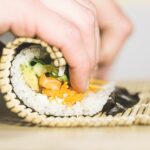 person rolling sushi